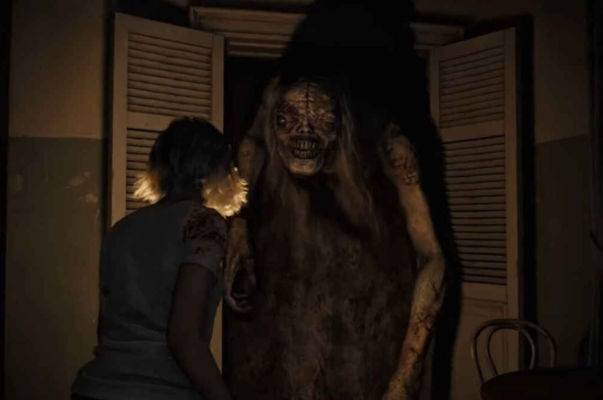 Criatura monstruosa surge em ambiente escuro em Resident Evil Requiem.