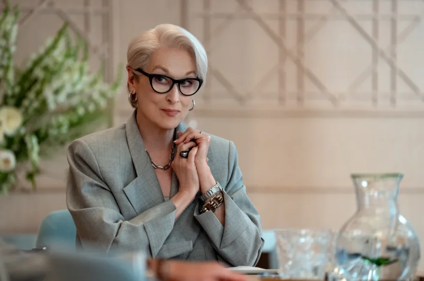 Meryl Streep como Miranda Priestly em cena de "O Diabo Veste Prada 2", vestindo blazer cinza e óculos pretos.